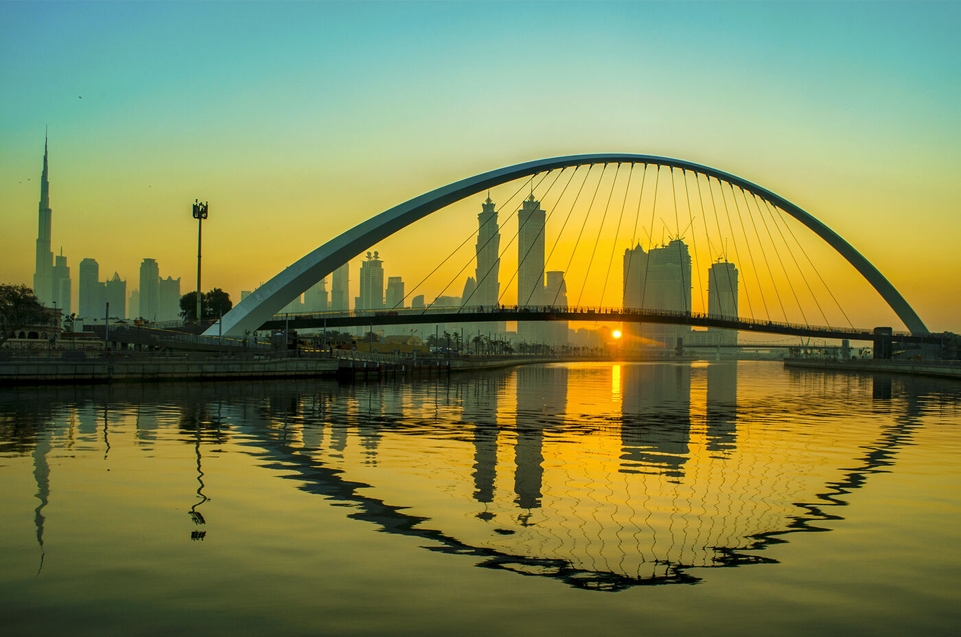 Tolerance Bridge arching over the Dubai Water Canal at sunrise